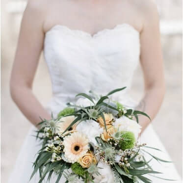 Photo d'une mariée tenant son bouquet, création de bijoux sur mesure lille.